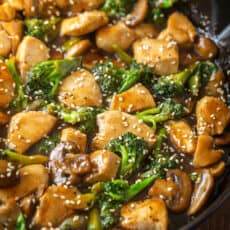 Chicken and broccoli stir fry in skillet garnished with sesame seeds