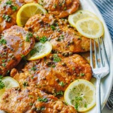 Easy Chicken piccata recipe served on a dish with lemon slices and capers