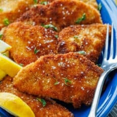 Crispy Chicken Schnitzel on a plate with lemon wedges