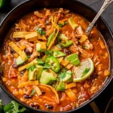 chicken Tortilla Soup garnished with avocado, cilantro and lime