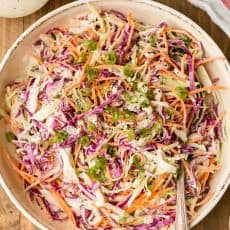 Coleslaw in bowl with dressing on the side
