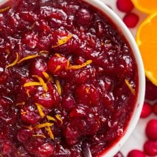 Cranberry sauce recipe served in bowl garnished with orange zest