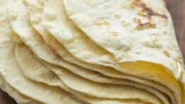A stack of homemade flour tortillas folded in half.