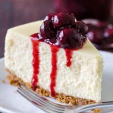 Slice of cheesecake on a plate topped with cherry sauce
