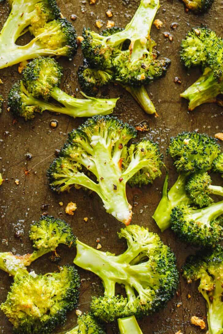Broccoli florets oven roasted on a baking sheet. 