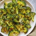Oven Roasted Broccoli served on white plate with parmesan cheese