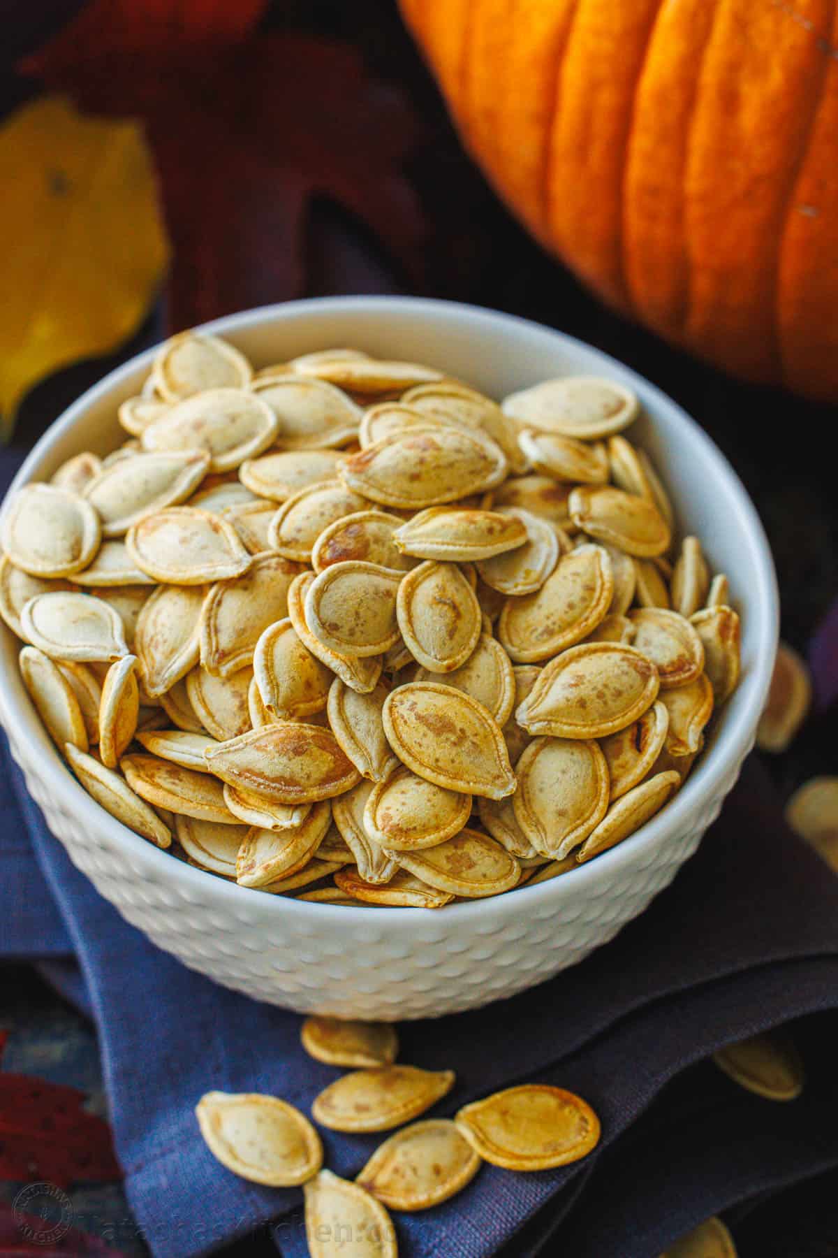 Pumpkin seeds roasted and seasoned in a white bowl