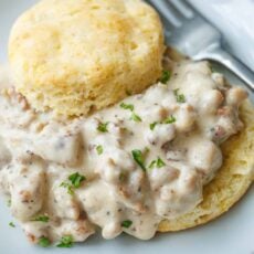 Close up of homemade biscuits and gravy on a plate with a fork