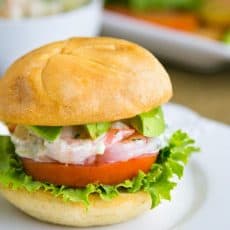 A close up shrimp sandwich on a white plate