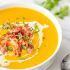 Sweet Potato Soup garnished with bacon bits, fresh parsley, and coconut milk